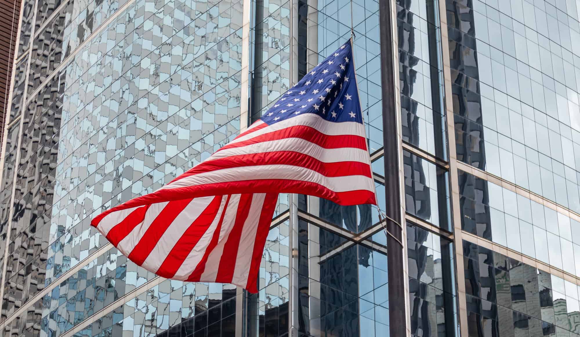 American flag in Chicago, Illinois downtown. Glass facade buildings background.