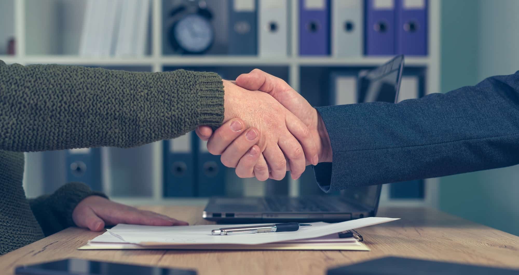 Man and woman shaking hands over business agreement