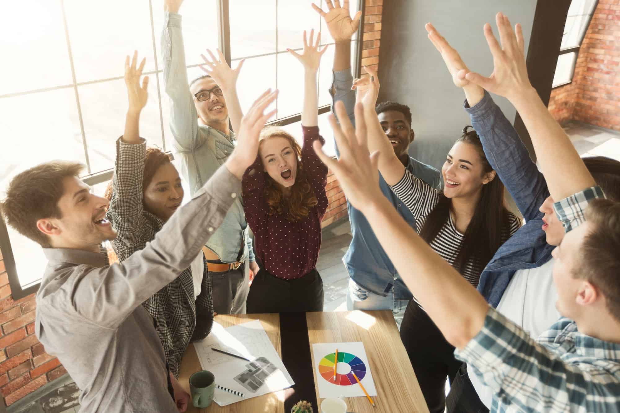 Young team celebrating successful project in modern office