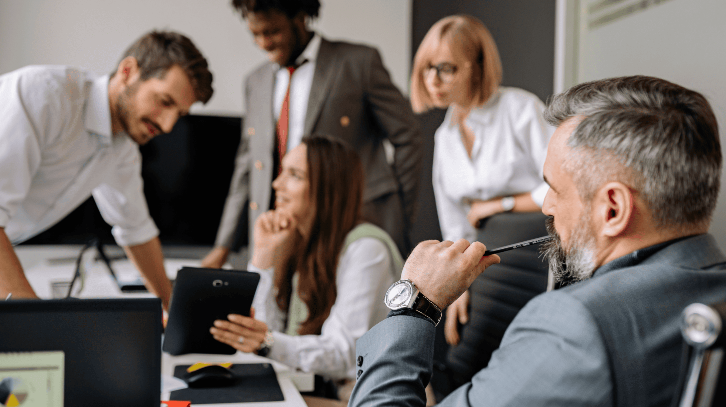 Executive search consultants and senior leaders reviewing candidate profiles and performance data during a C-suite hiring strategy meeting.