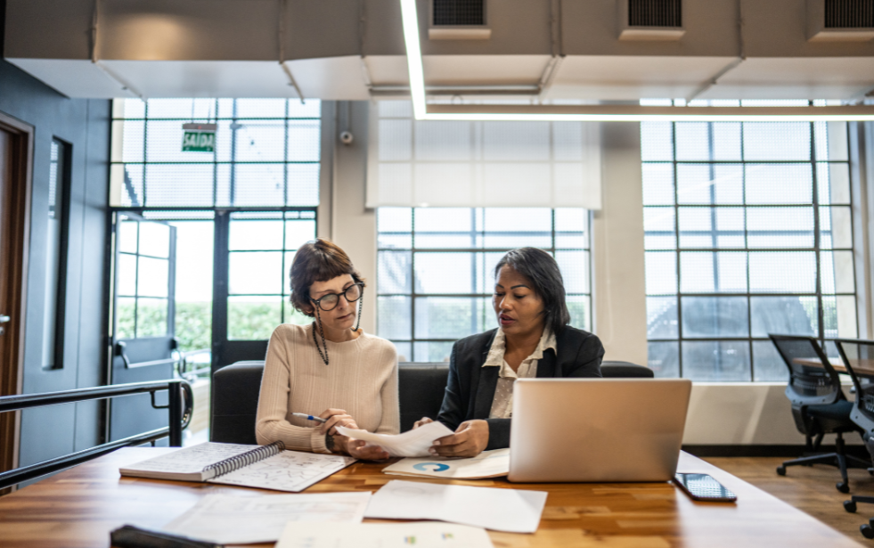 Two professionals collaborating in a modern office setting.