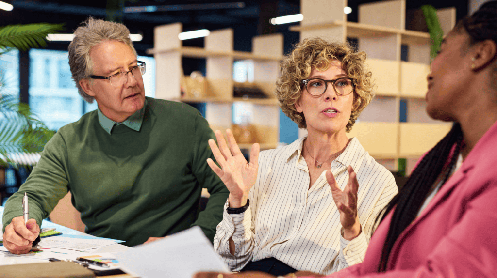 Three executives meeting to debate whether they should hire a generalist or specialist executive search firm for their organization’s open C-suite position.