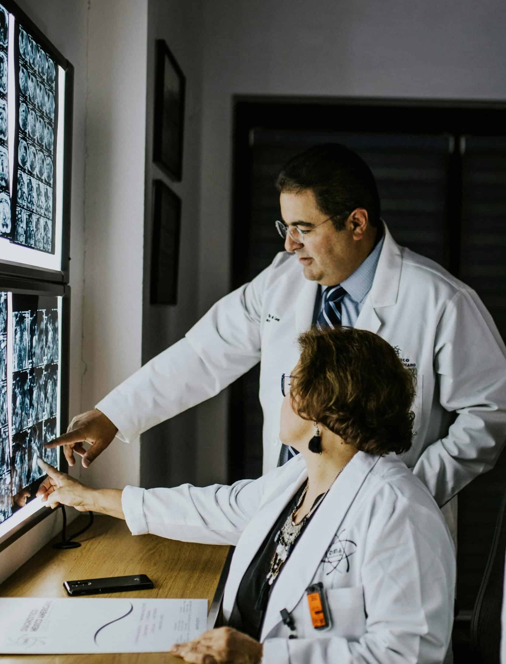 Twee artsen beoordelen medische scans ter ondersteuning van een wervingsprocedure voor leidinggevende functies in de gezondheidszorg.