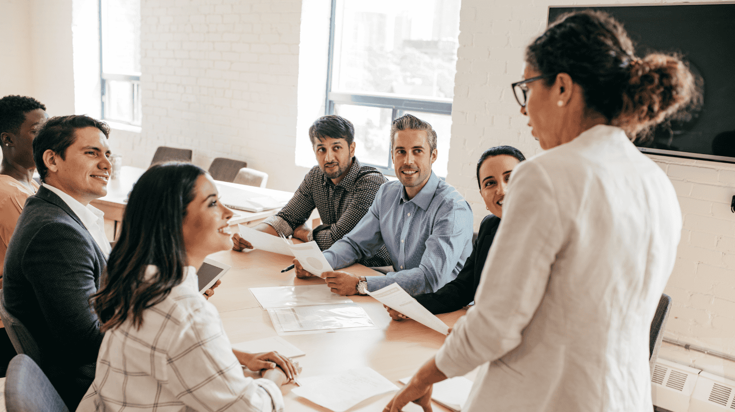 Executive leading a team meeting, coaching leaders through common leadership mistakes.