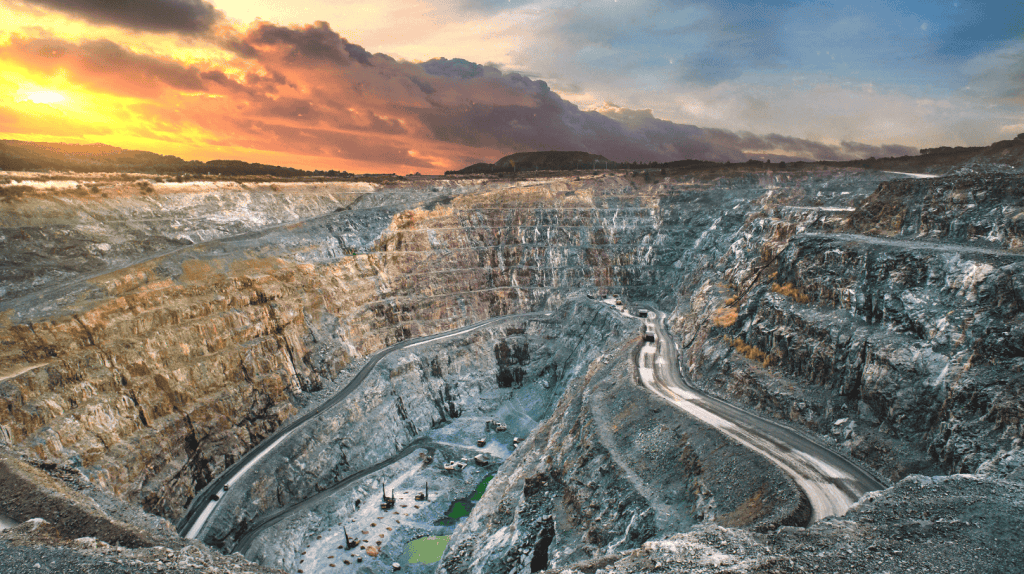 Aerial view of an open-pit mine with excavators and a conveyor belt system.