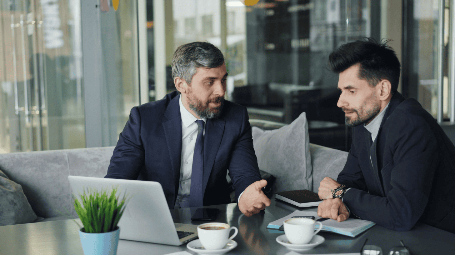 Senior executive discussing leadership development with a colleague during an executive coaching conversation.