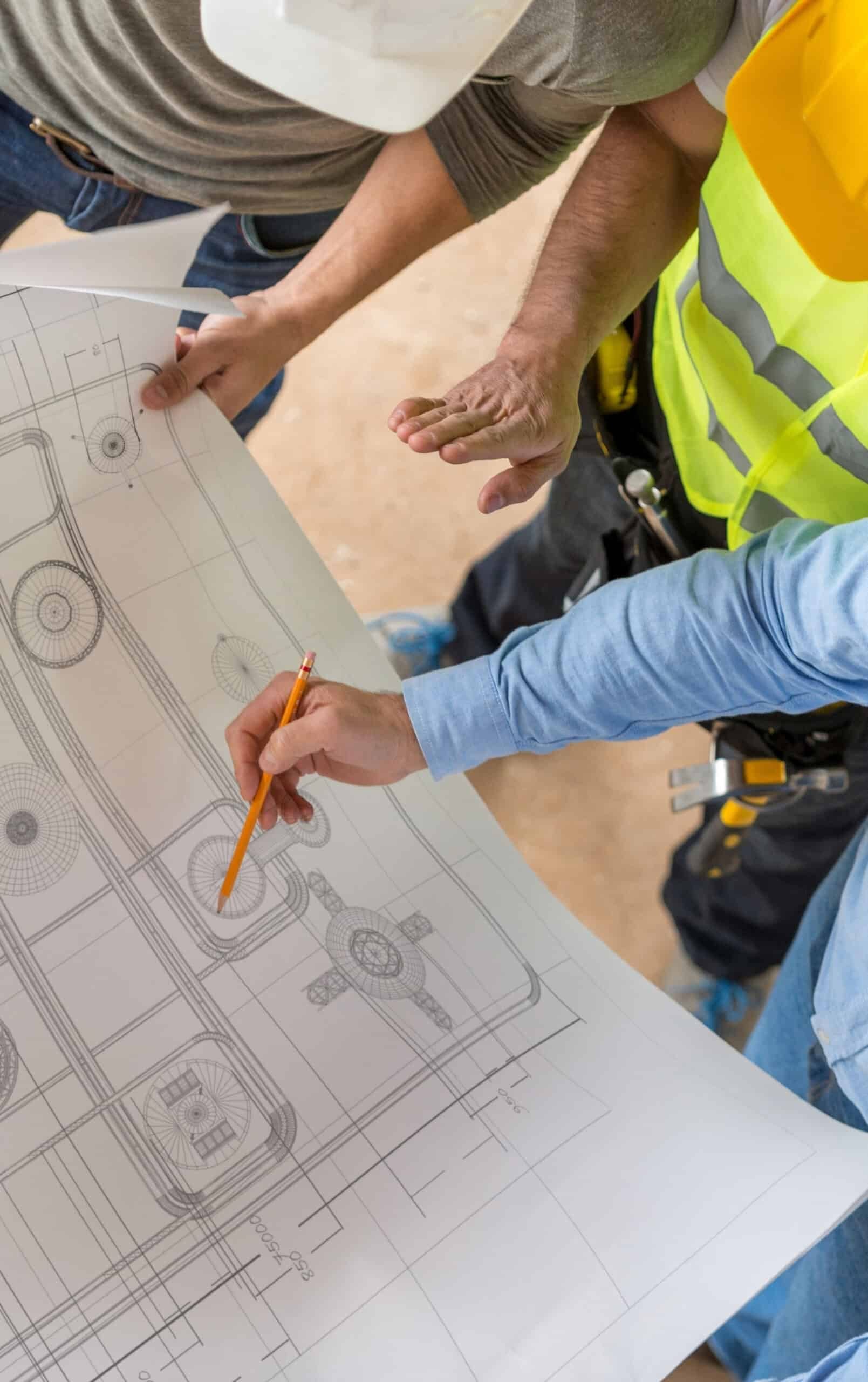 Ingenieurs en bouwkundigen die bouwtekeningen bekijken op een bouwlocatie in de zakelijke en professionele dienstverlening.
