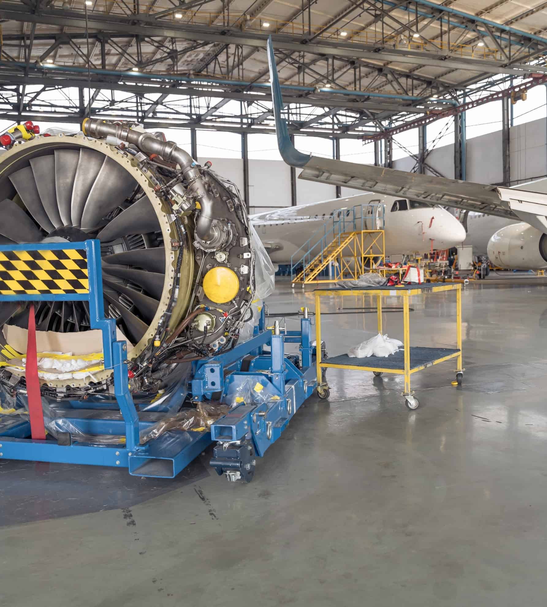 Een turbofanmotor op een onderhoudsplatform in een vliegtuigloods, een scène die centraal staat in de luchtvaartindustrie.