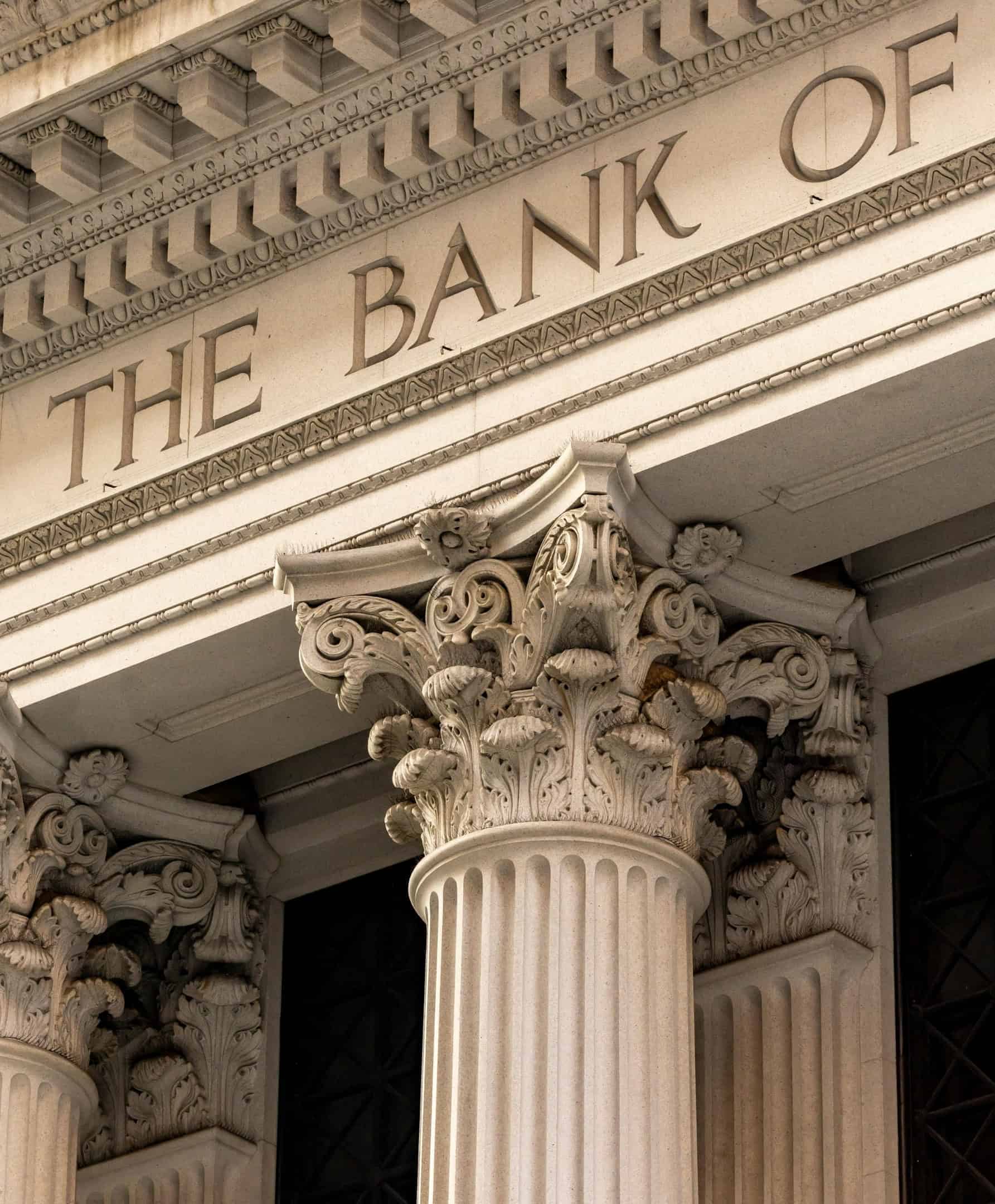 Columnas ornamentadas y fachada de piedra tallada de una institución bancaria clásica.