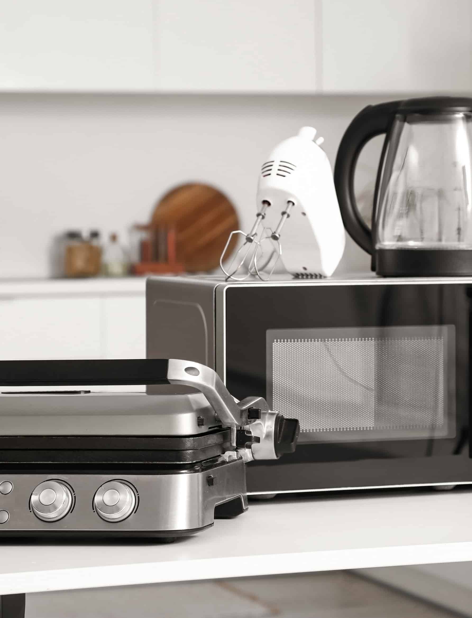 Kitchen consumer durables including a home grill, microwave, and an electric kettle.