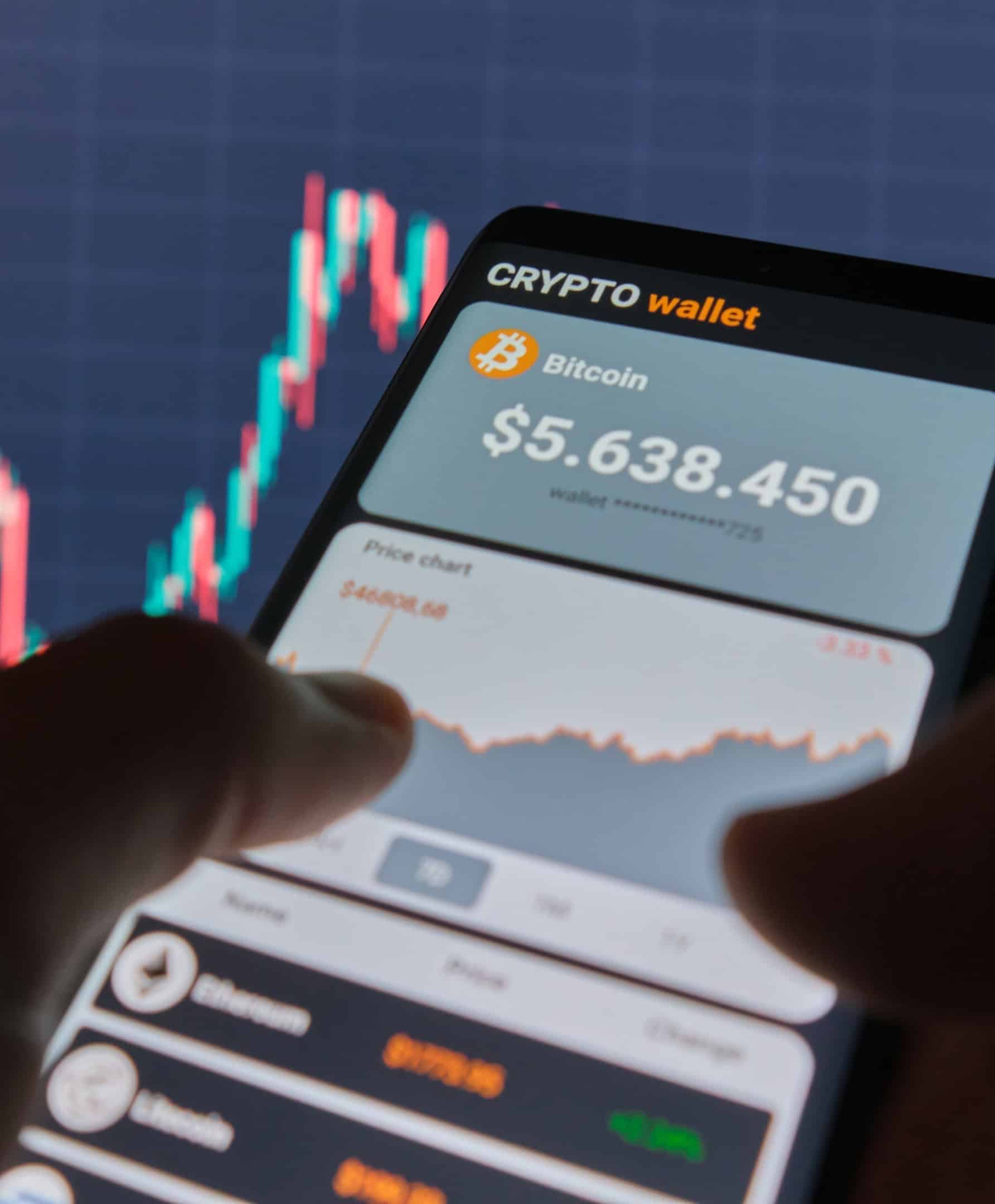 Smartphone que muestra una billetera de criptomonedas Bitcoin y un gráfico de precios en la industria de las criptomonedas y los activos digitales.