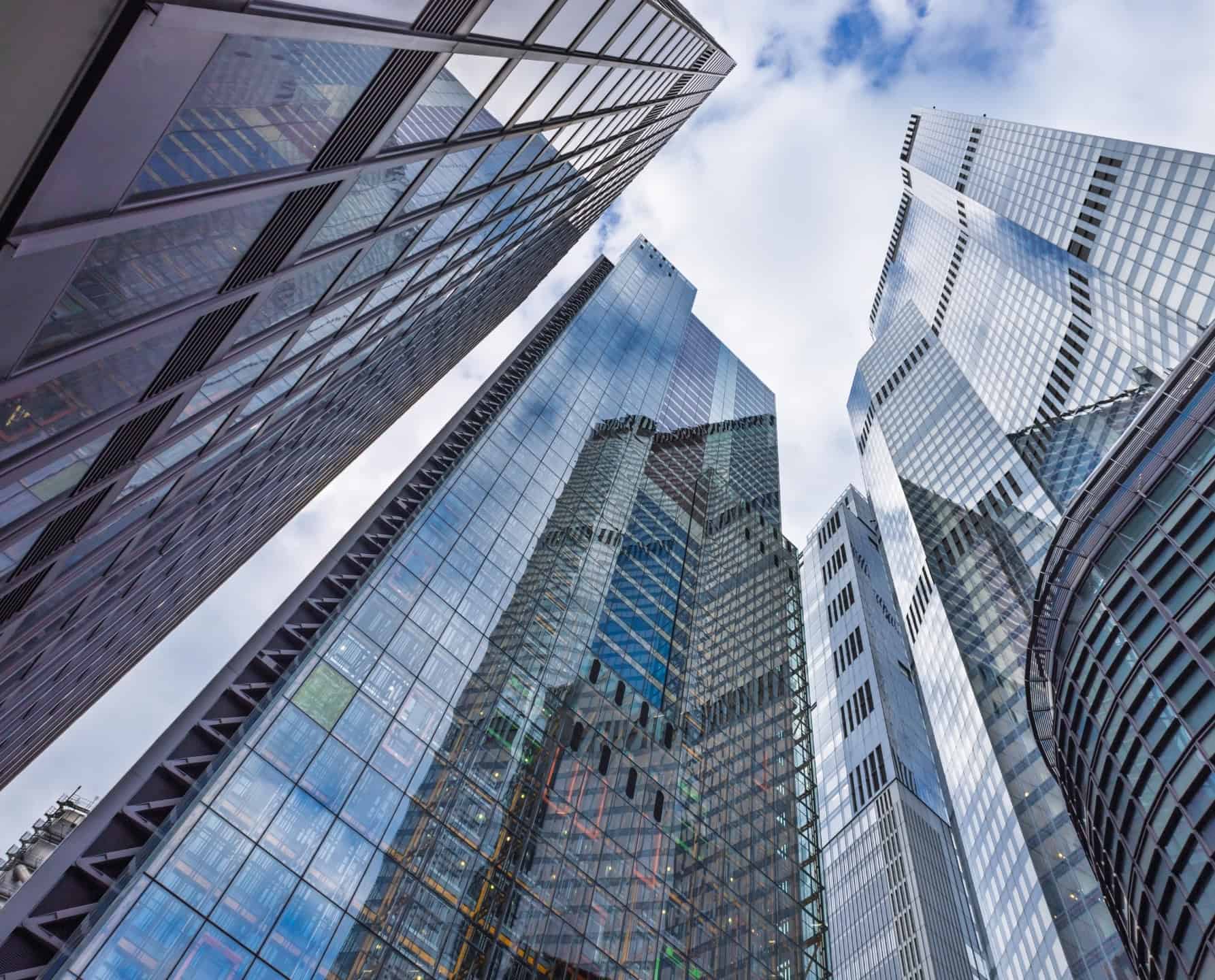 Laag perspectief van glazen wolkenkrabbers van groeikapitaalbedrijven in een financieel district.