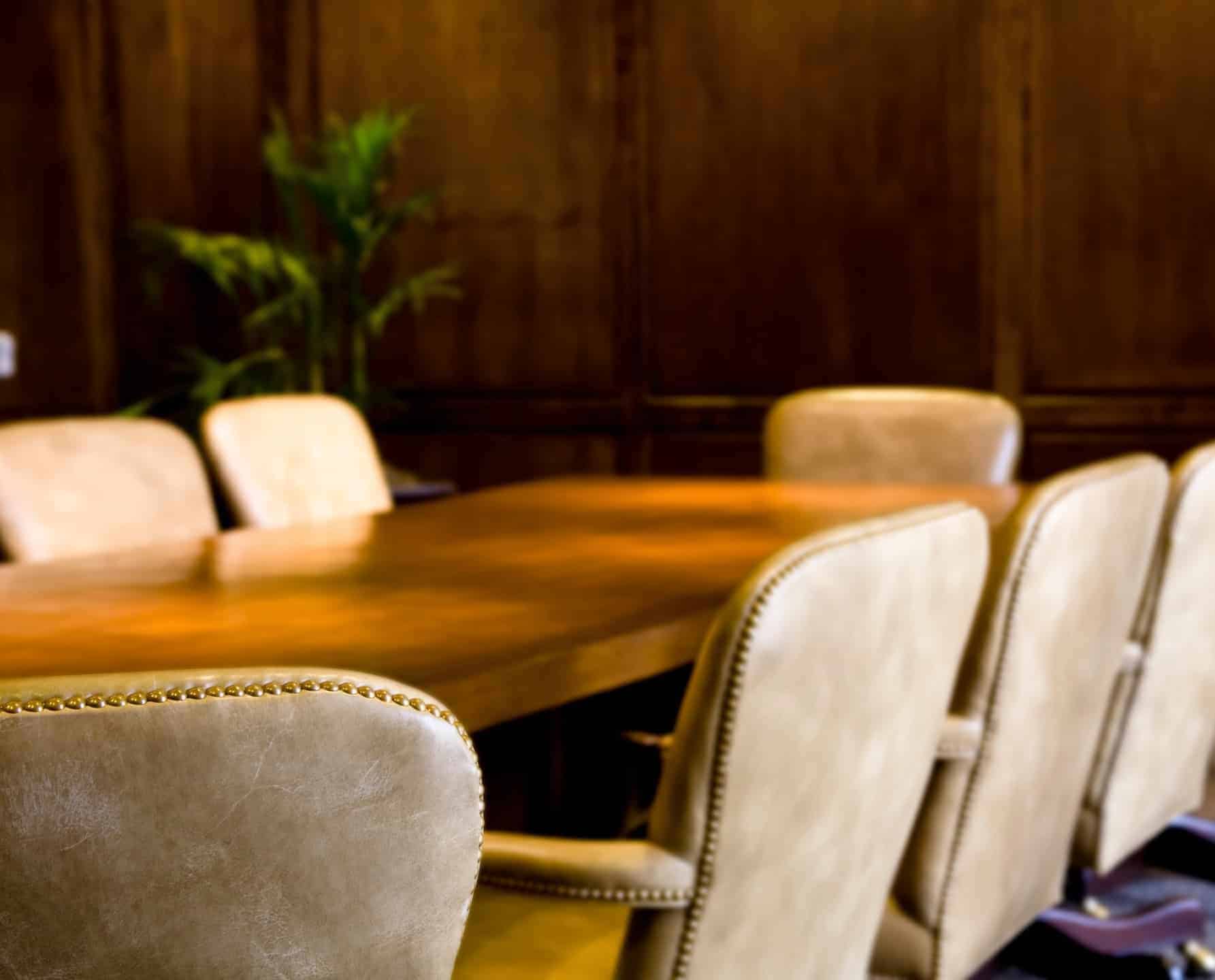 Lege vergaderruimte met leren stoelen bij een pensioenfonds en vermogensbeheerder.