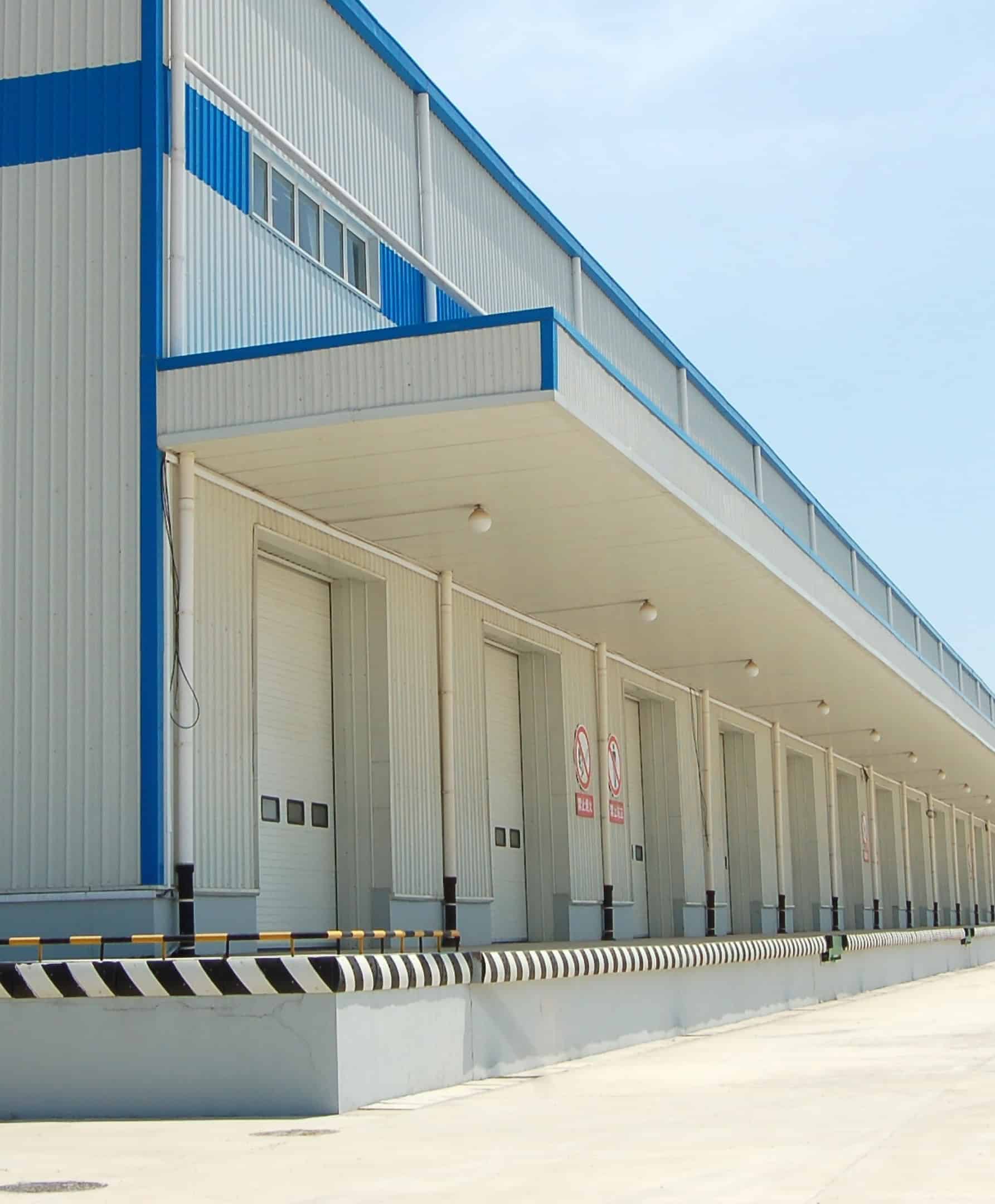 Nave industrial con muelles de carga, representativa de las propiedades de un fideicomiso de inversión inmobiliaria.