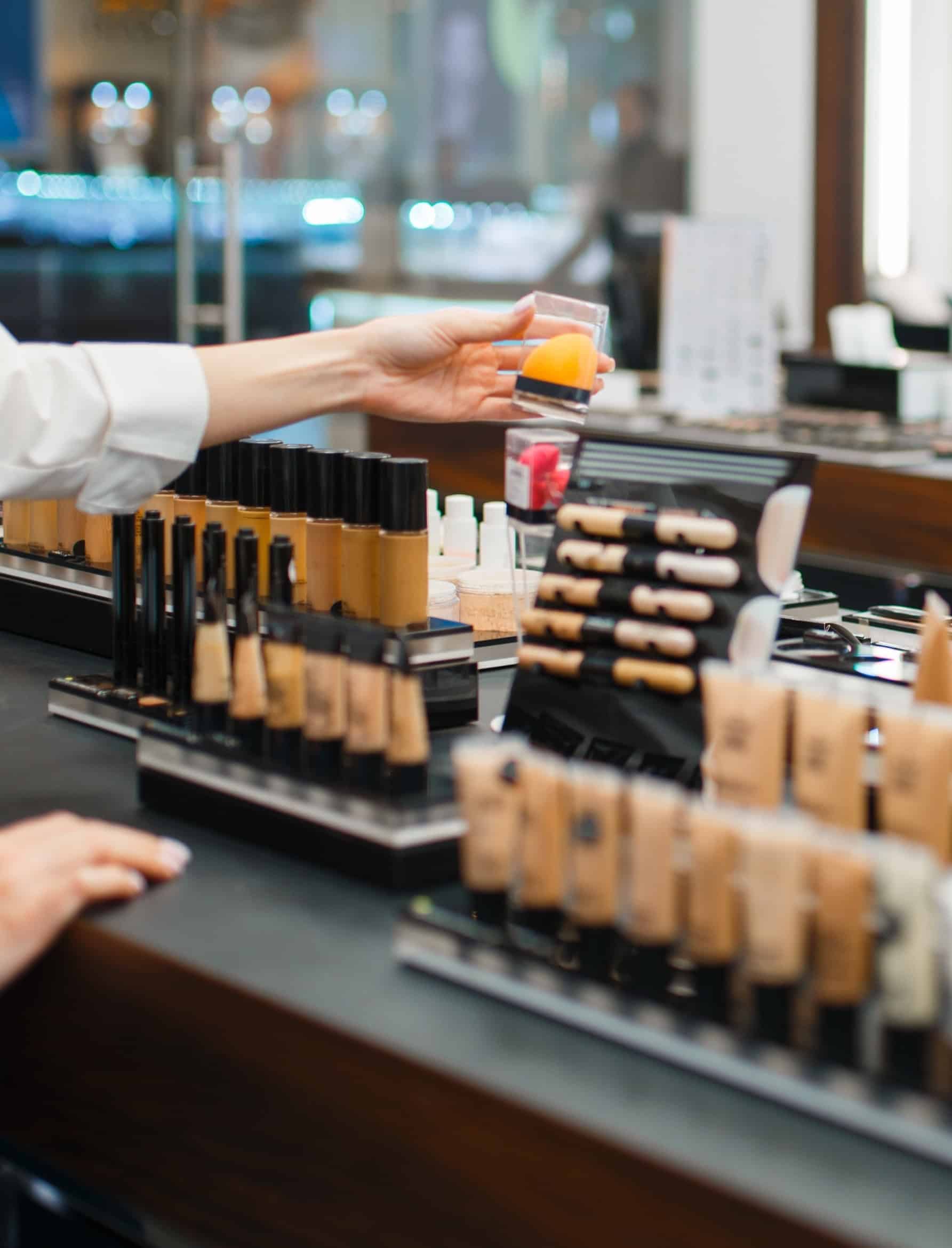 Prestige beauty counter with foundation products and makeup tools in a cosmetics retail setting.