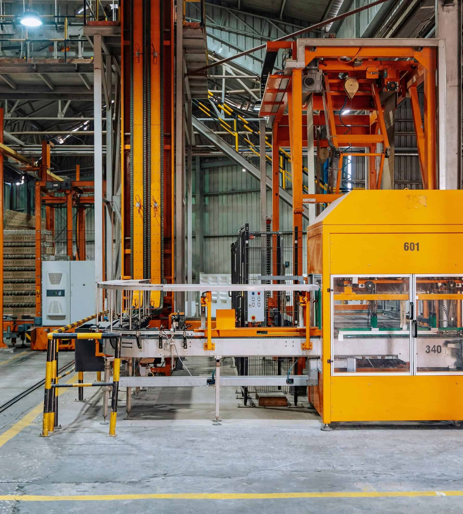 Geautomatiseerde materiaalbehandelingssystemen en industriële machines in een fabriekshal, een kernactiviteit binnen de industriële automatisering.