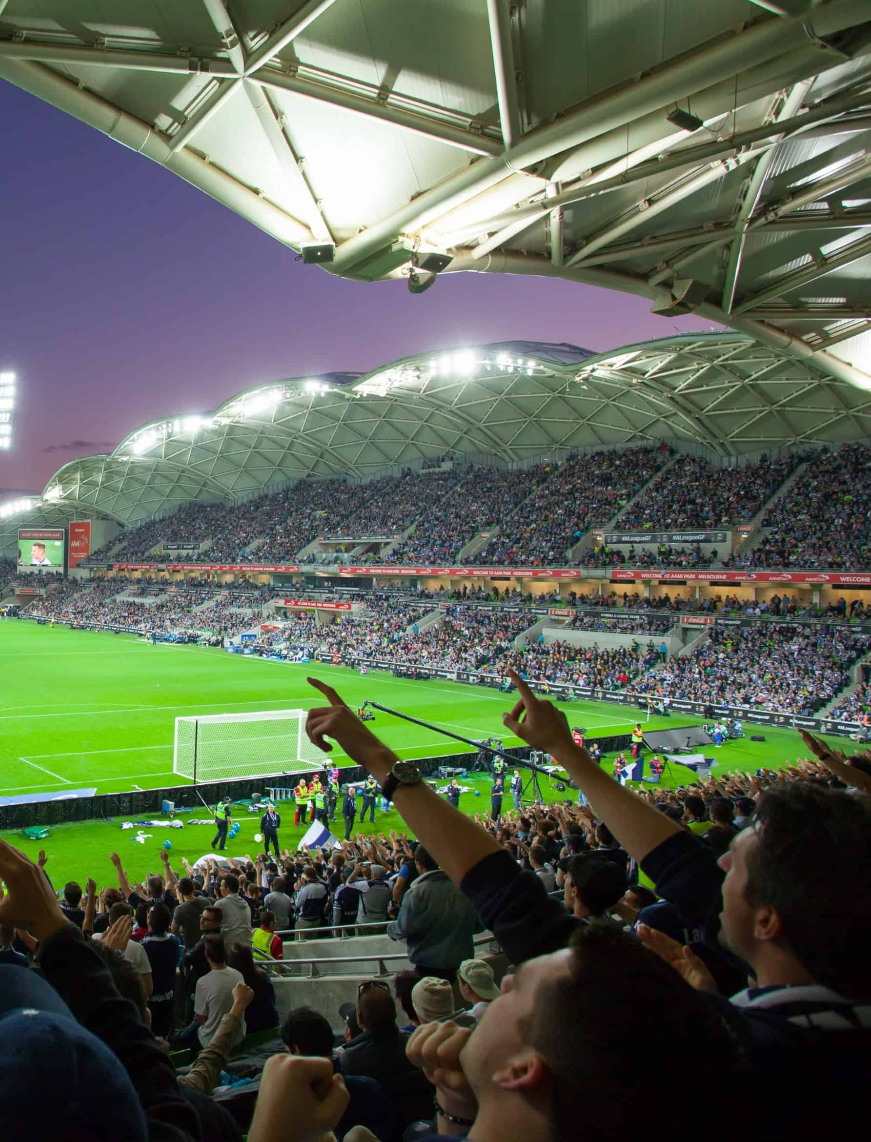Packed soccer stadium with cheering fans at a night match in the sports industry.